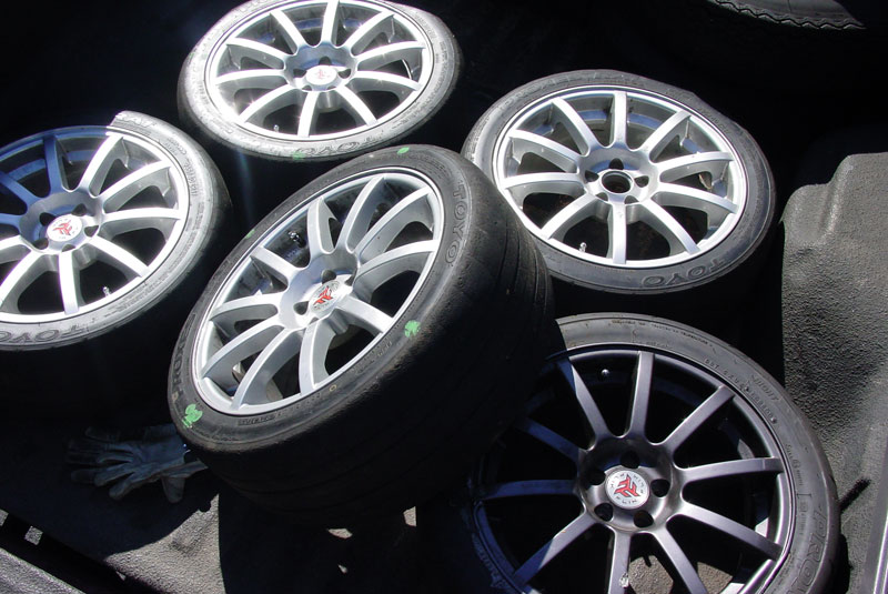 Four silver rims and one black rim the black rim is broken from the 